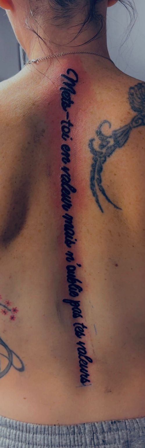 Tatouage lettering citation motivante colonne vertebrale dos Hakuna Tattoo