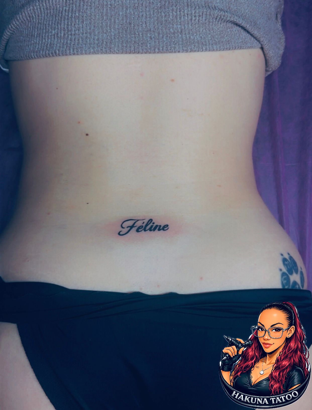 Tatouage encre rouge Feline cursif bas du dos Hakuna Tattoo Arpajon