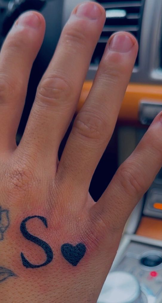 Tatouage lettering lettre S avec petit coeur en encre noire sur la main Hakuna Tattoo Arpajon